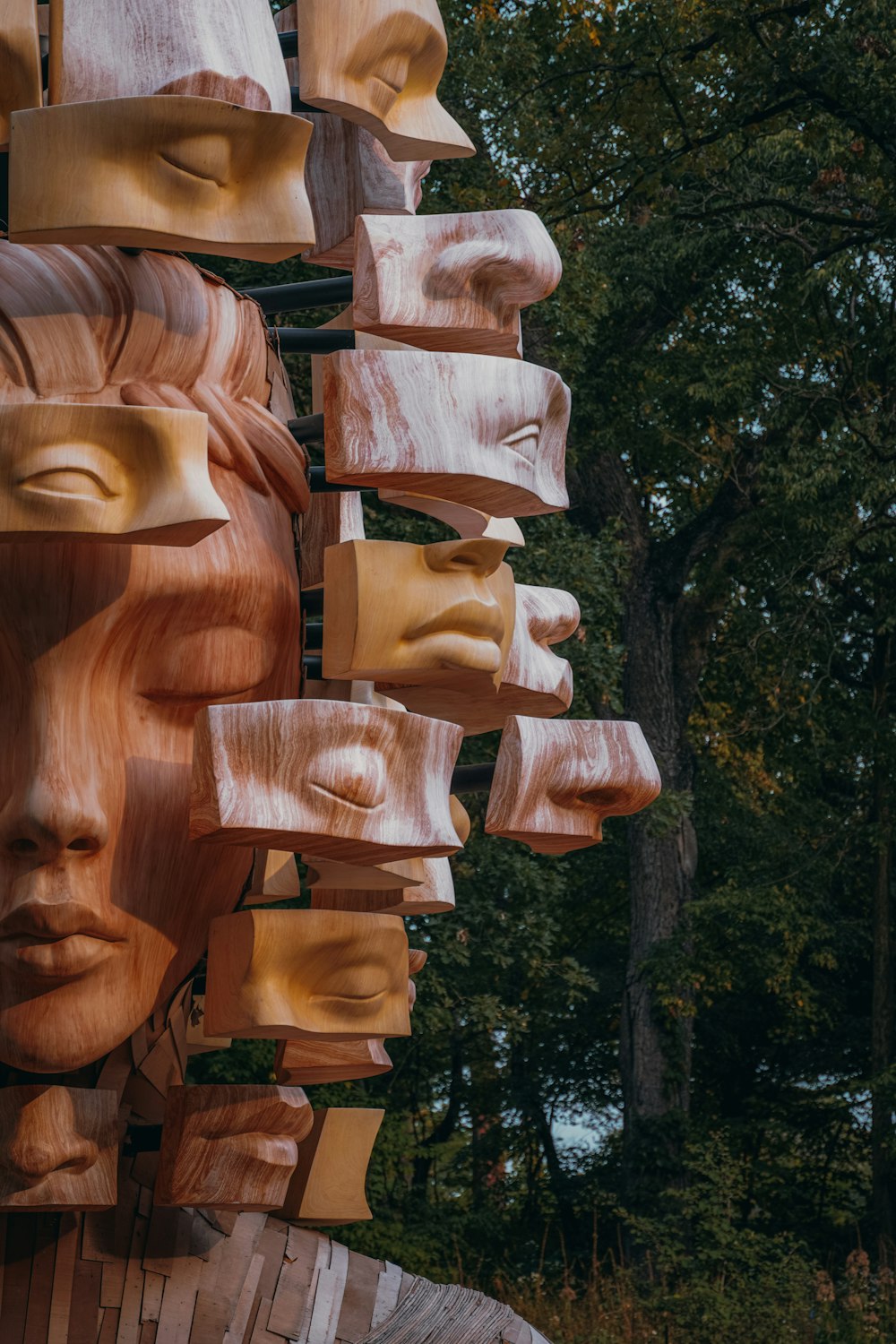 a sculpture made of wood with many faces on it