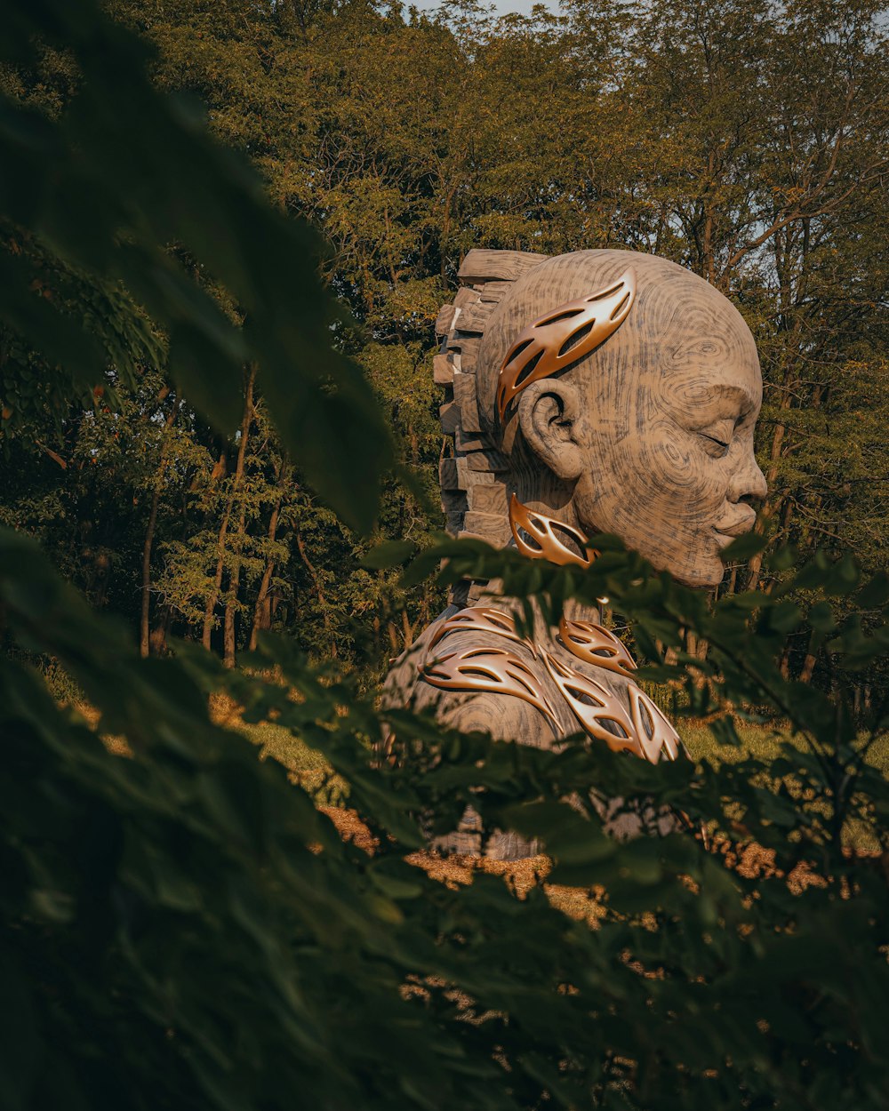 a statue of a person in a wooded area