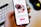 A hand holds a smartphone displaying a dating app interface. The screen shows profiles of adults with a text 'Dating for grown-ups' encouraging registration to connect with singles nearby. Profiles are highlighted with circular images.