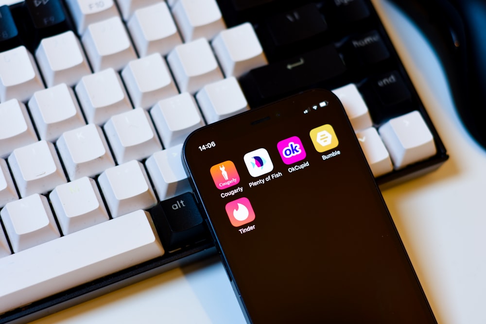 a cell phone sitting next to a keyboard