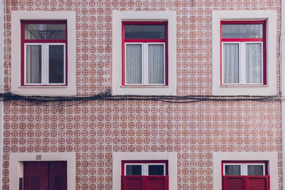 a tall building with red shutters and windows