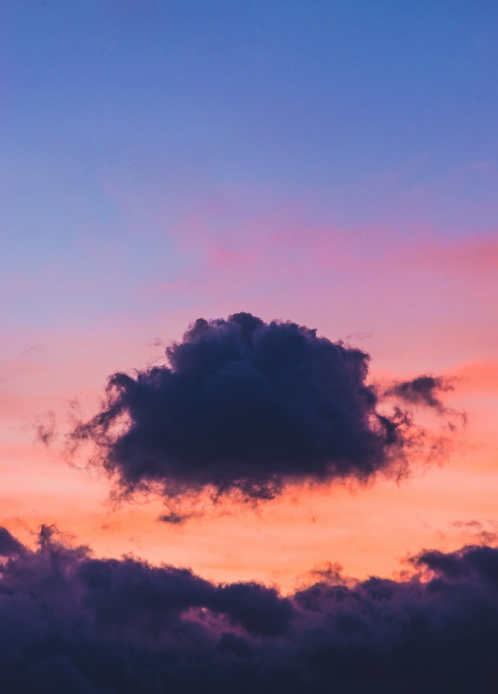 a plane flying in the sky at sunset