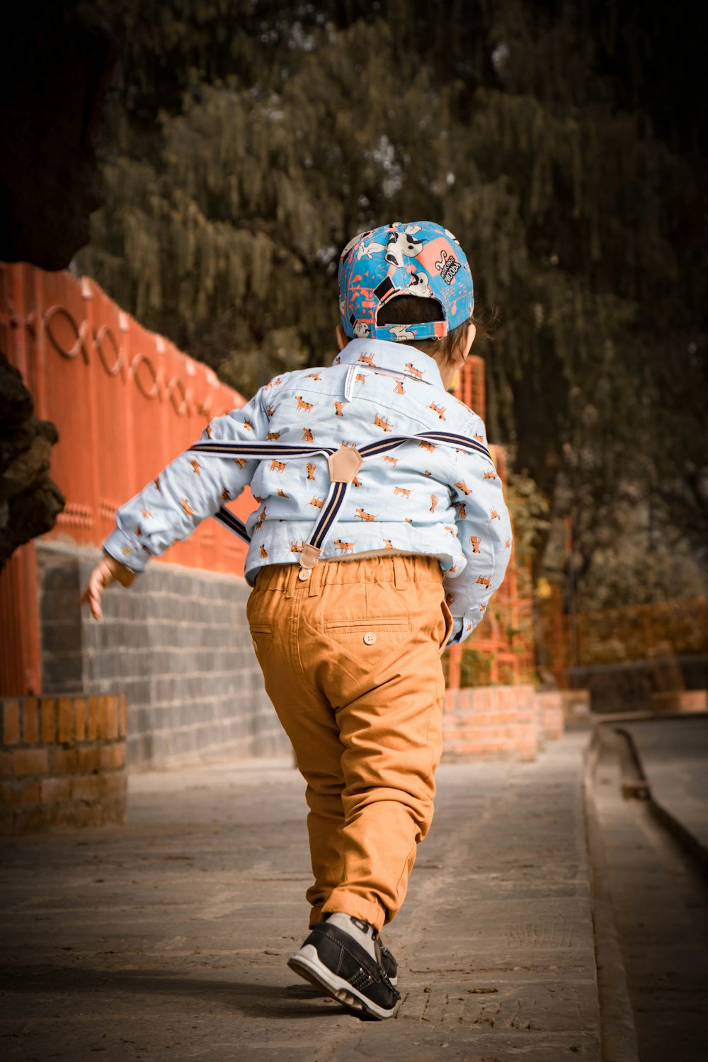 a young boy riding a skateboard down a sidewalk