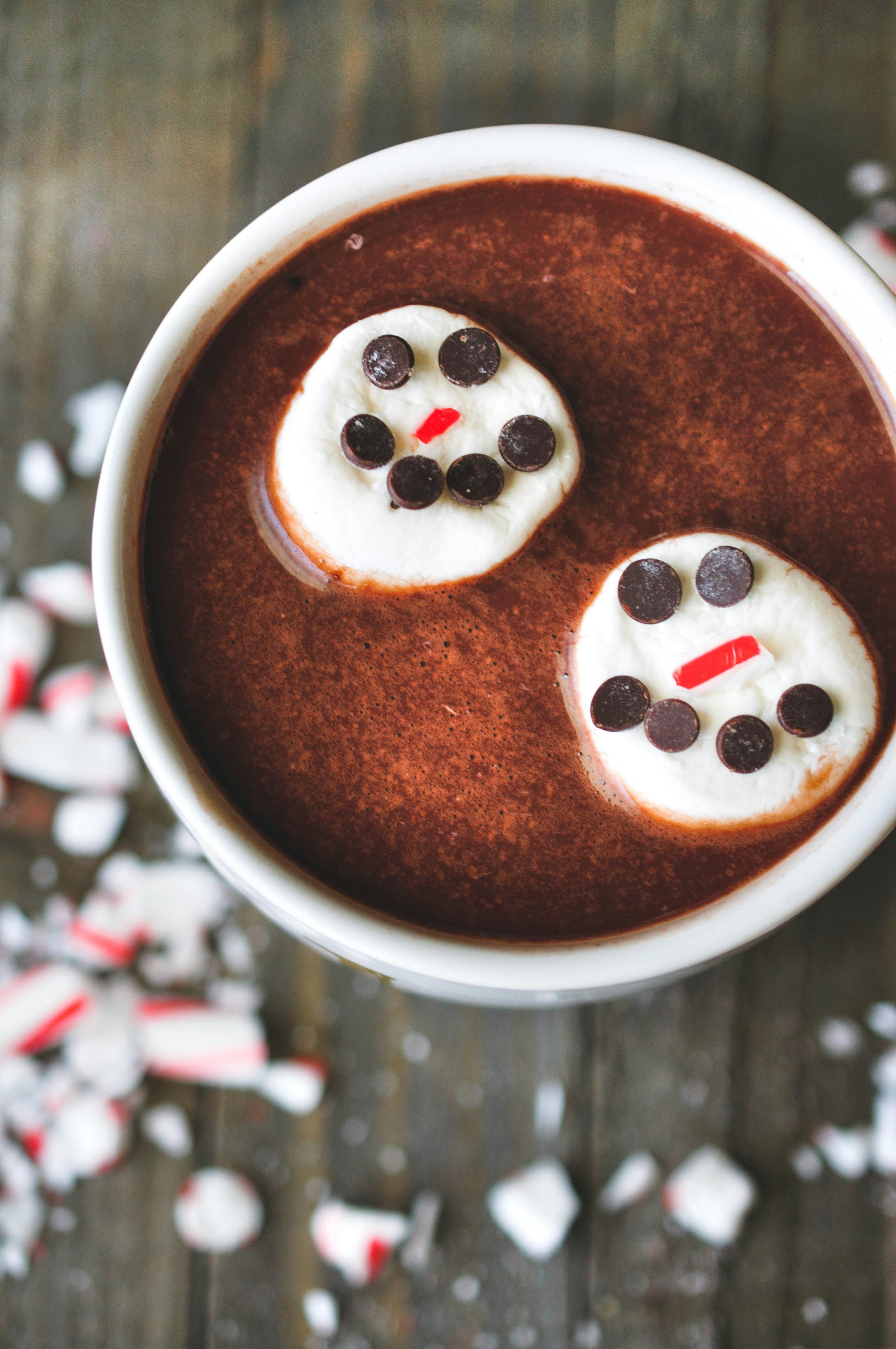 une tasse de chocolat chaud avec des guimauves et des yeux en chocolat