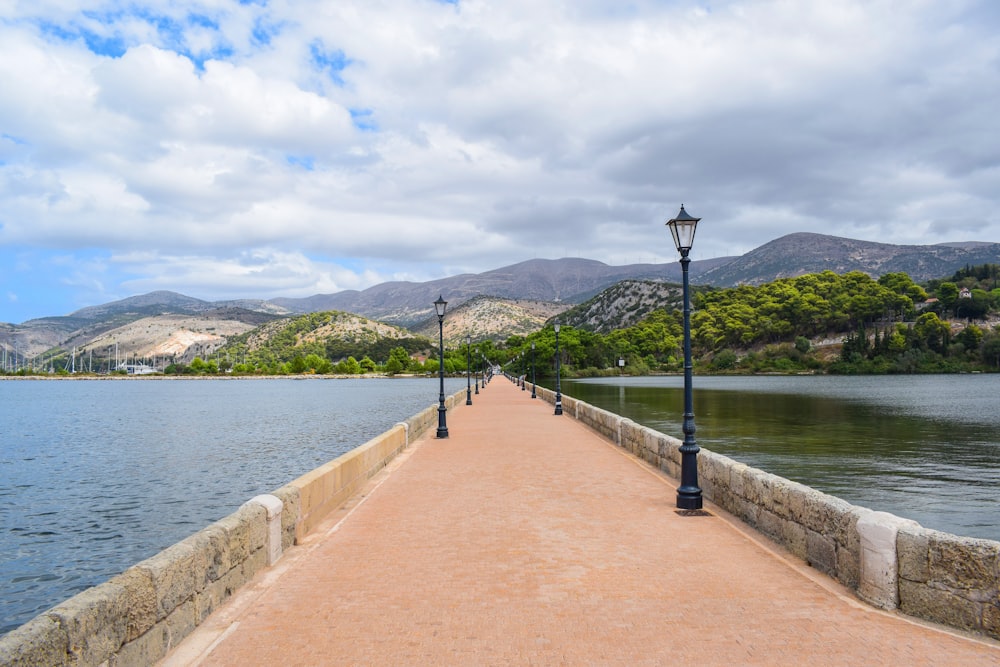 una pasarela que conduce a un lago con montañas al fondo