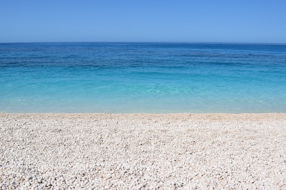 une plage de sable avec un océan bleu en arrière-plan