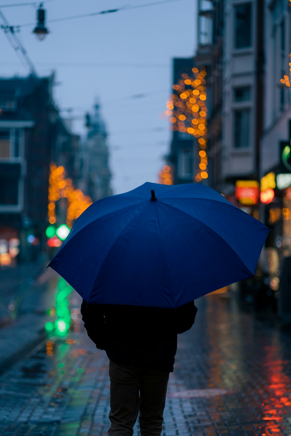 Eine Person, die eine Straße entlang geht und einen Regenschirm hält