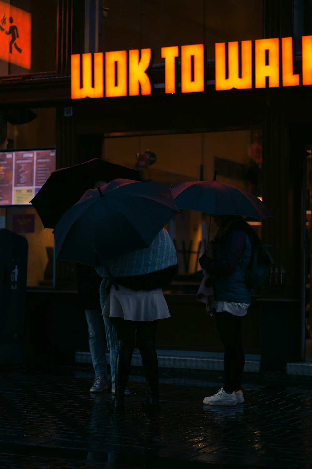 Ein paar Leute stehen unter Regenschirmen im Regen