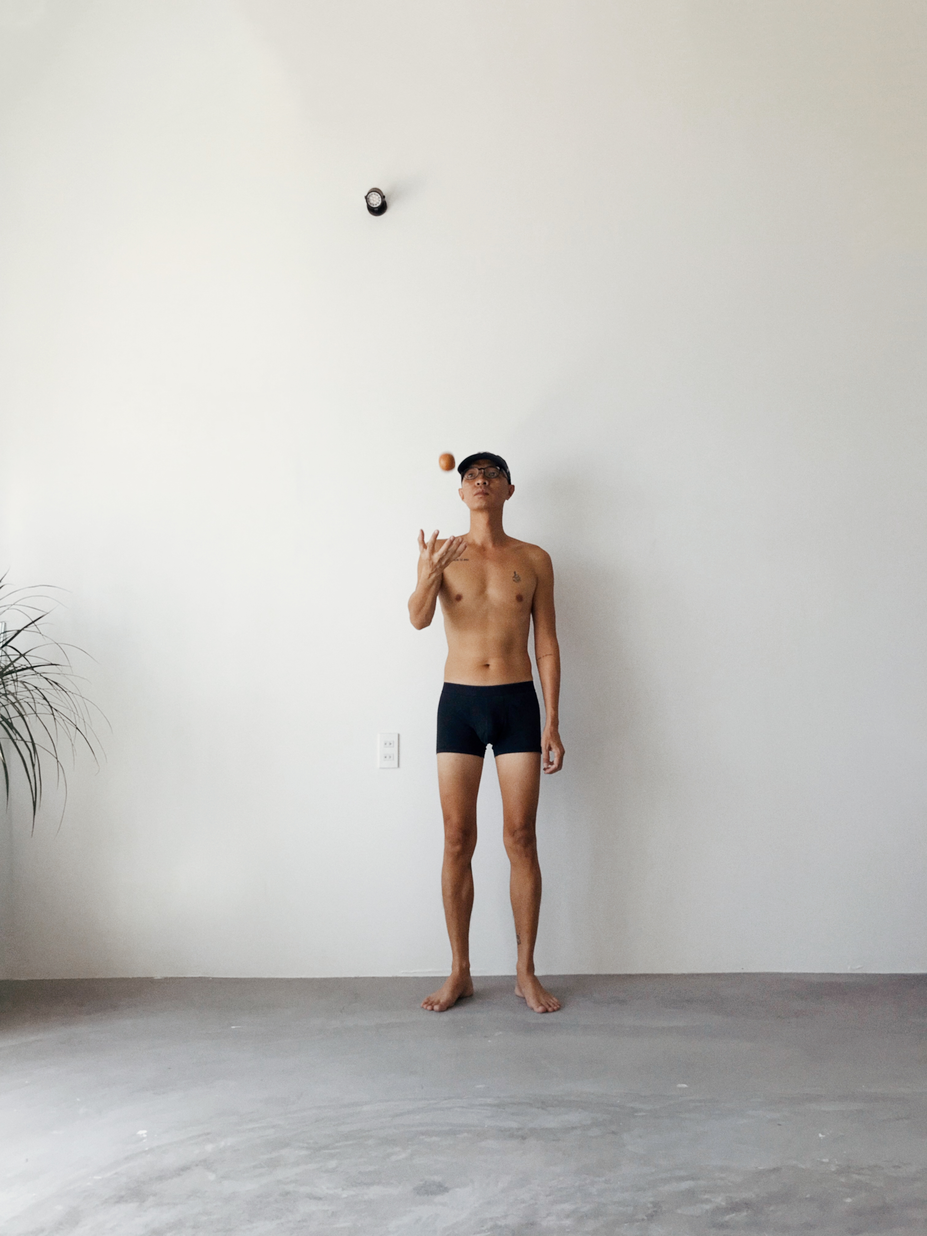 um homem em pé na frente de uma parede branca