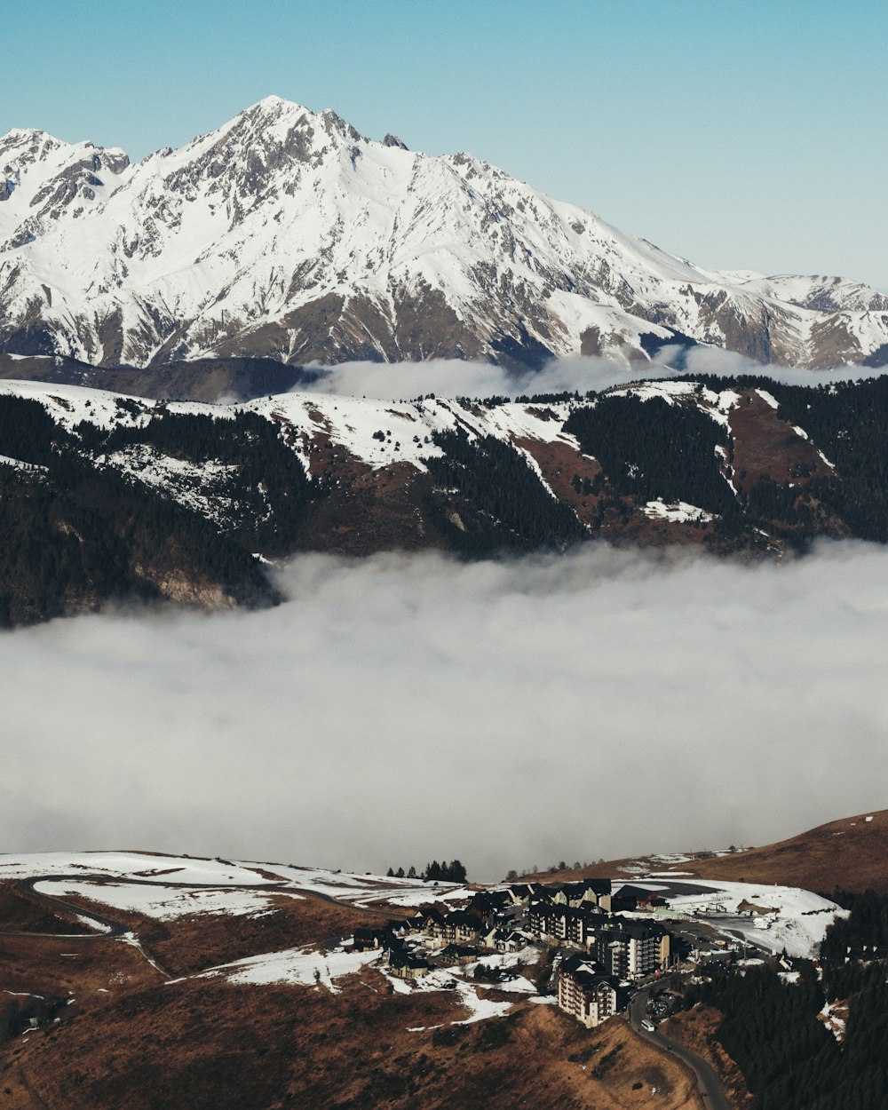 a snow covered mountain range with a building in the foreground