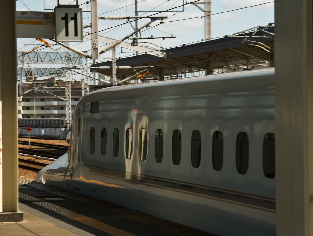 a white train traveling down train tracks next to a train station