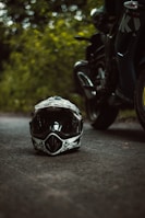 a helmet sitting on the side of a road next to a motorcycle