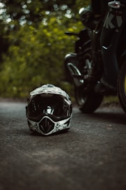 a helmet sitting on the side of a road next to a motorcycle
