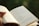 A close-up of a person reading a book outdoors.