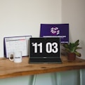 a laptop computer sitting on top of a wooden table