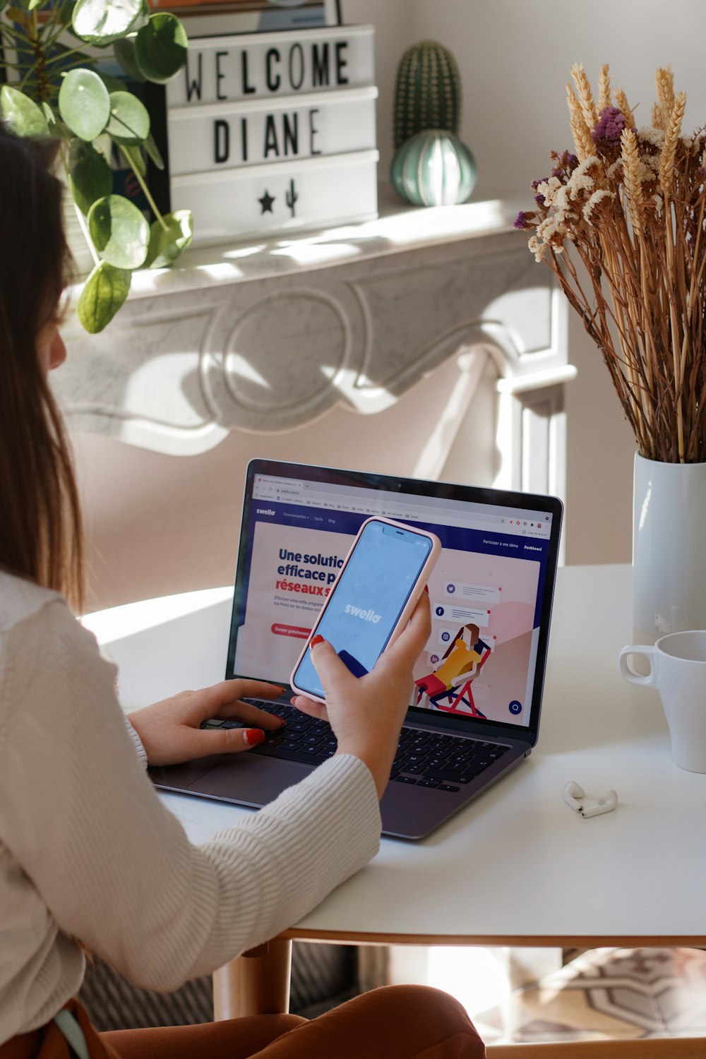 a woman sitting at a table using a laptop computer