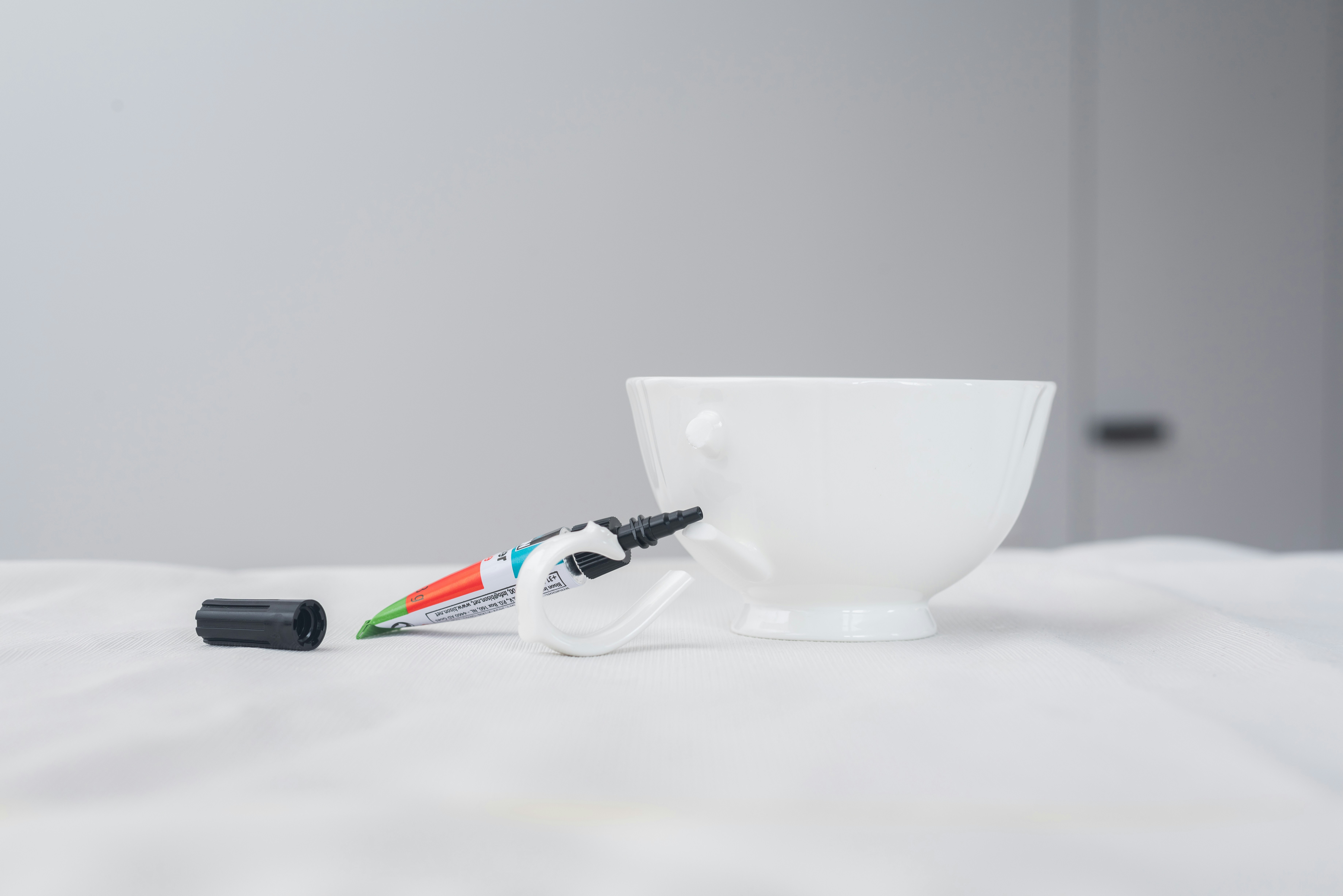 a white cup with two wires attached to it