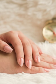 a woman's hand resting on a white fur