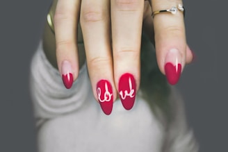 a woman's hand with a red and white manicure