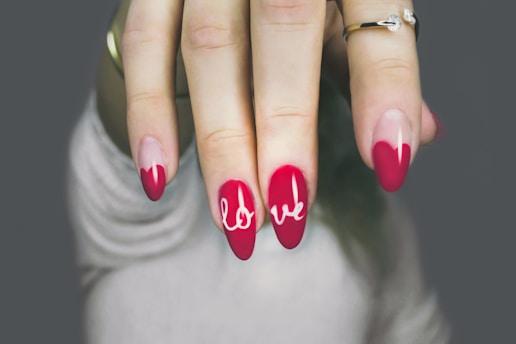 a woman's hand with a red and white manicure