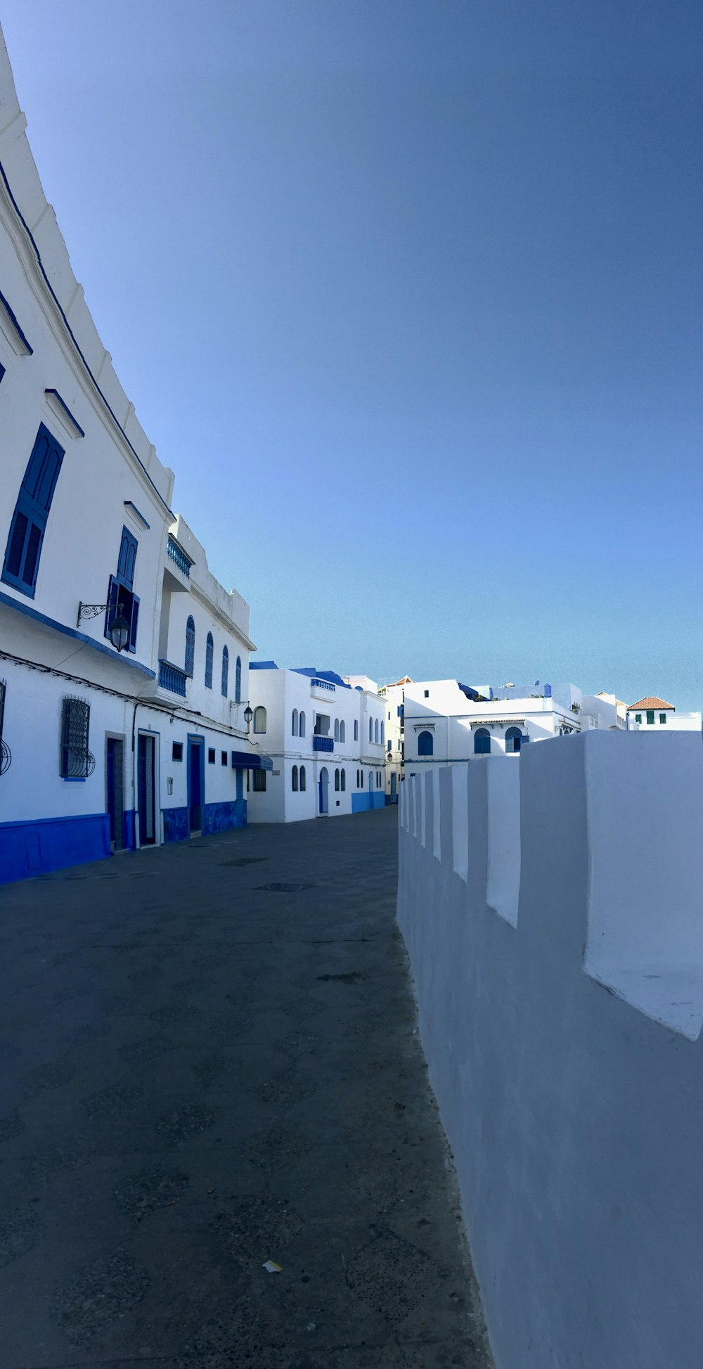 Ein weißes Gebäude mit blauen Fensterläden und Fenstern