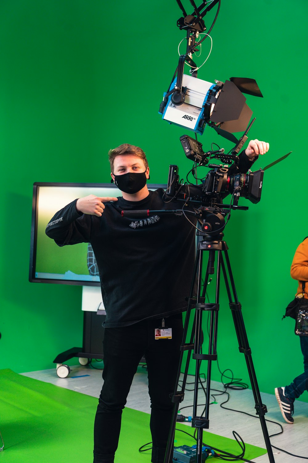 a man wearing a face mask standing in front of a camera
