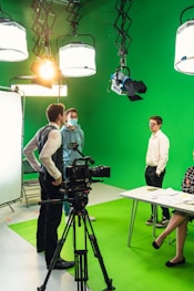 a group of people standing in front of a green screen