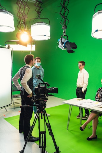 a group of people standing in front of a green screen
