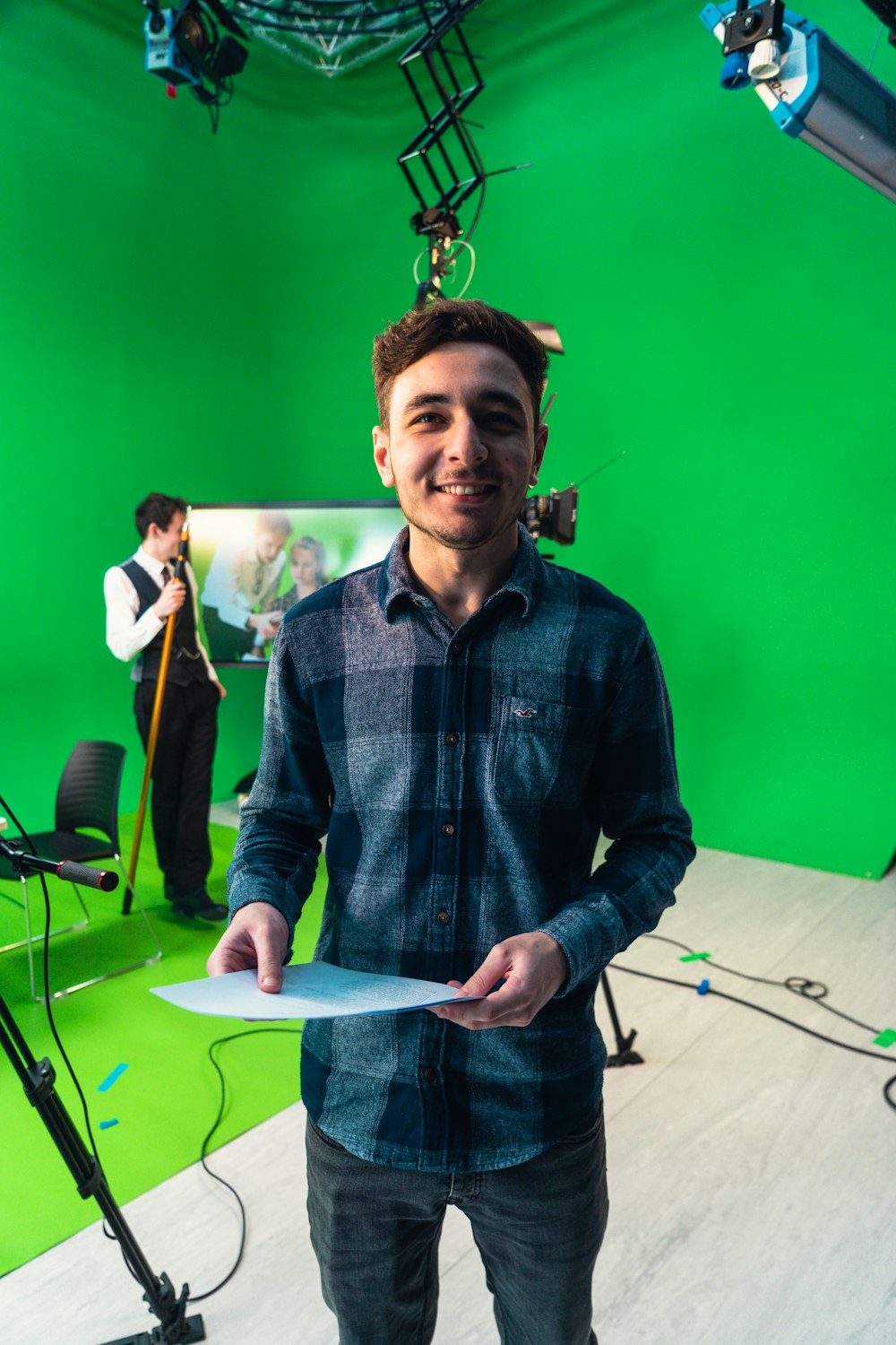 a man holding a piece of paper in front of a green screen