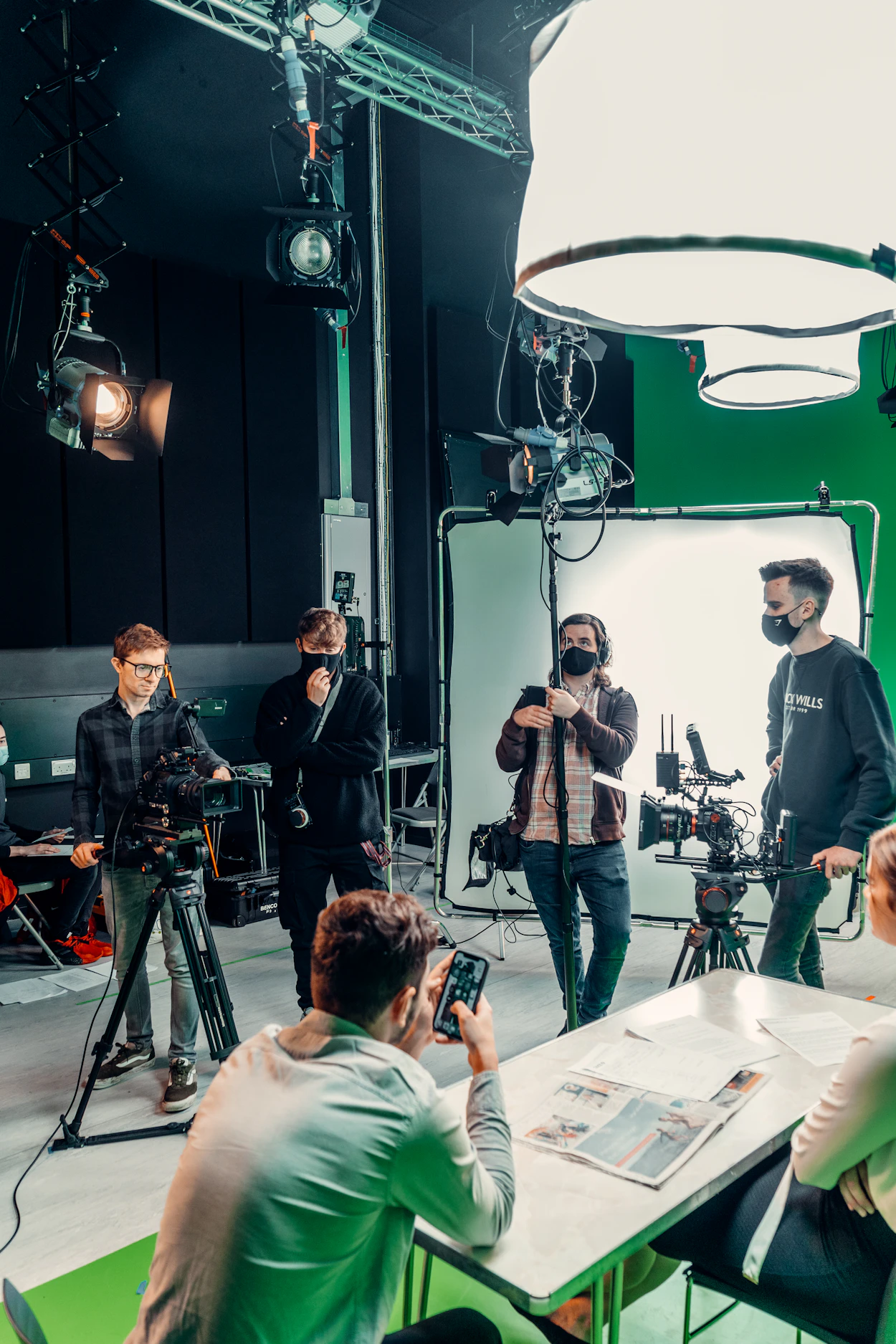 Equipo creativo trabajando con cámaras e iluminación en estudio audiovisual