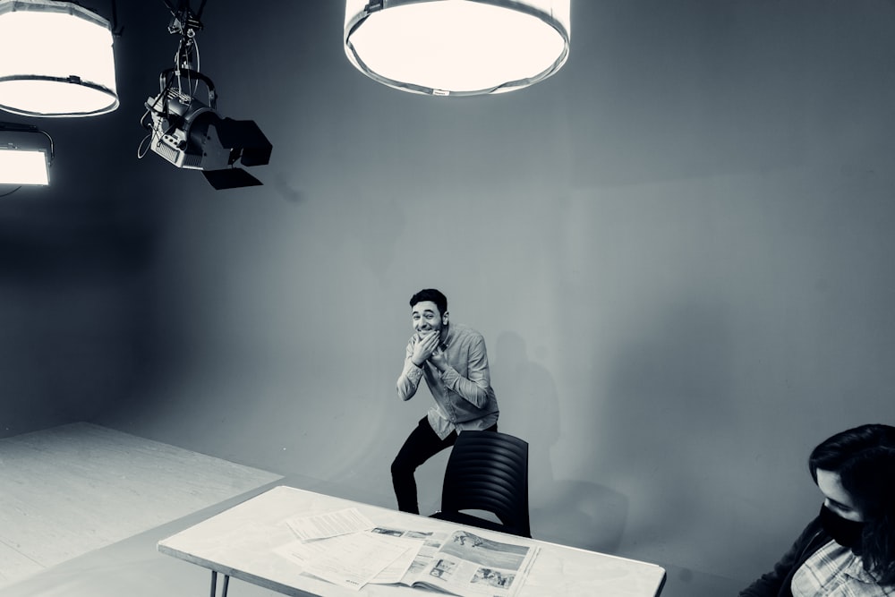 Un hombre sentado en una mesa frente a una cámara