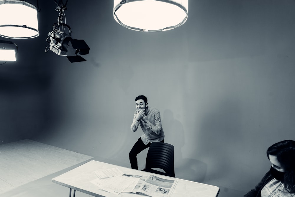 a man sitting at a table in front of a camera