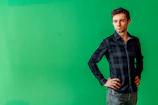 Actor posing confidently against a neutral backdrop.