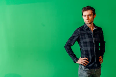 Actor posing confidently against a neutral backdrop.