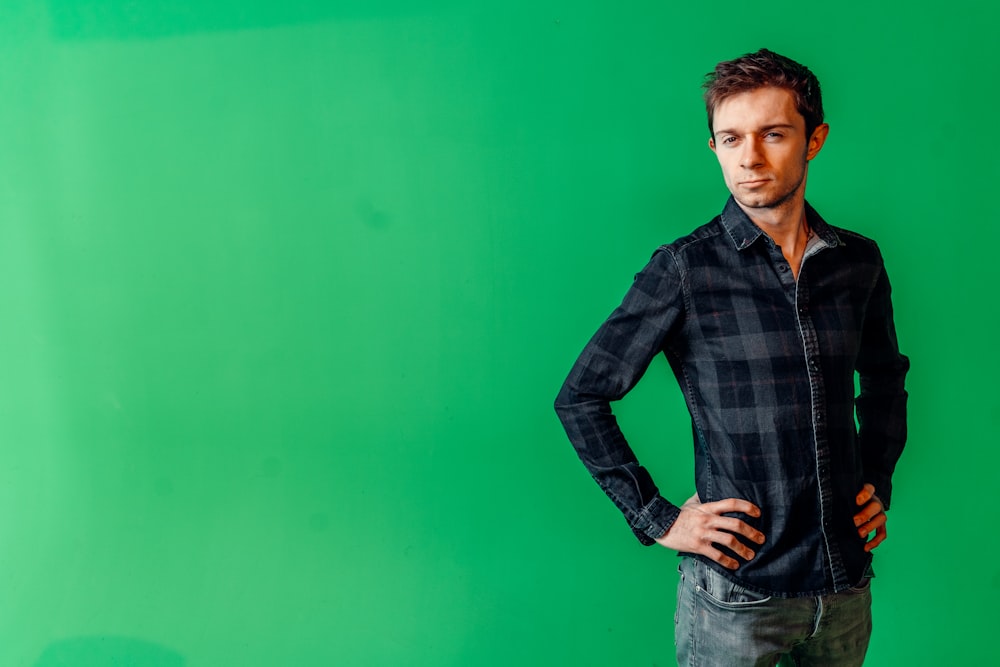 a man standing in front of a green background