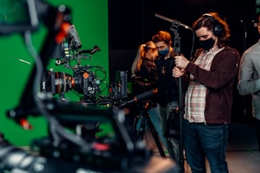 a group of people standing around a camera