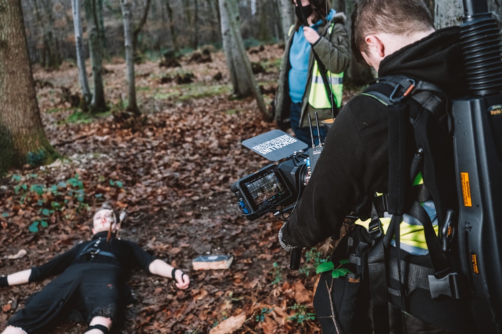 a man laying on the ground in the woods