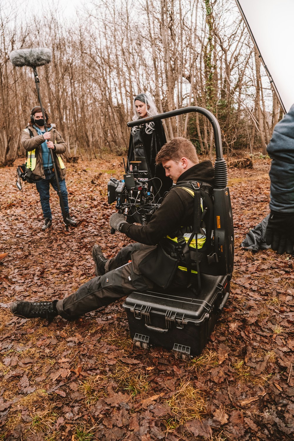 a man sitting on the ground in front of a camera