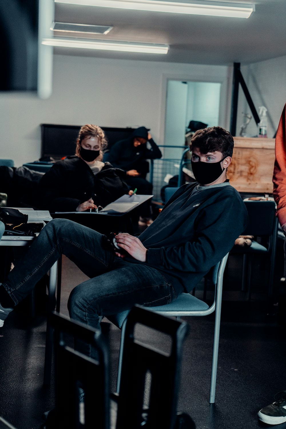 a man sitting in a chair wearing a face mask