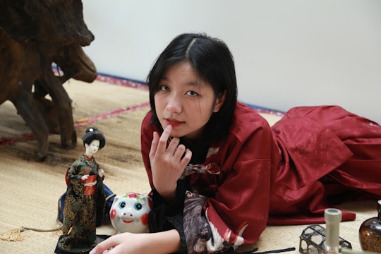 A researcher analyzing data with cultural artifacts surrounding them.
