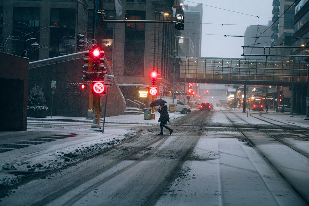 a person walking across a snow covered street