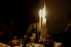 Evening fellowship meeting with candles lit, creating a warm and inviting atmosphere inside a cozy room.
