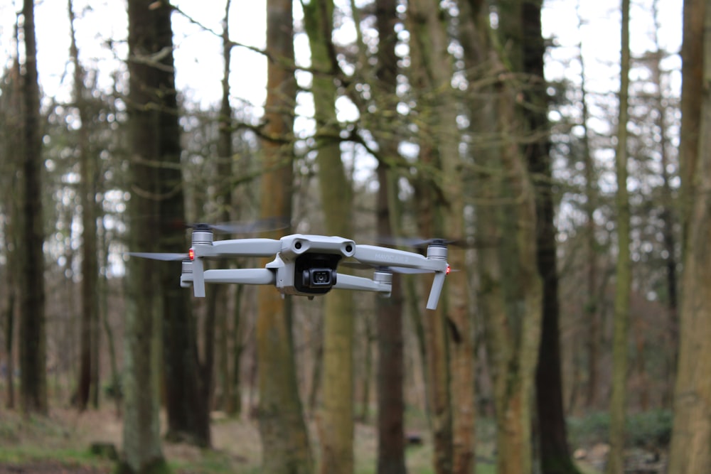 a remote controlled flying device in the middle of a forest