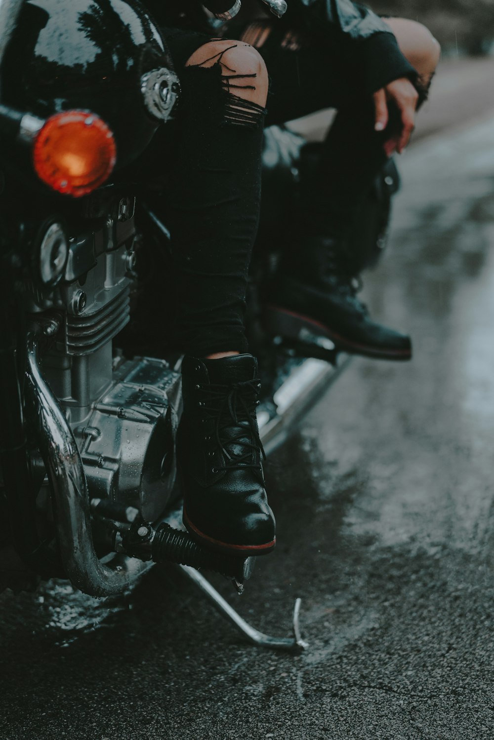 a man sitting on a motorcycle in the rain