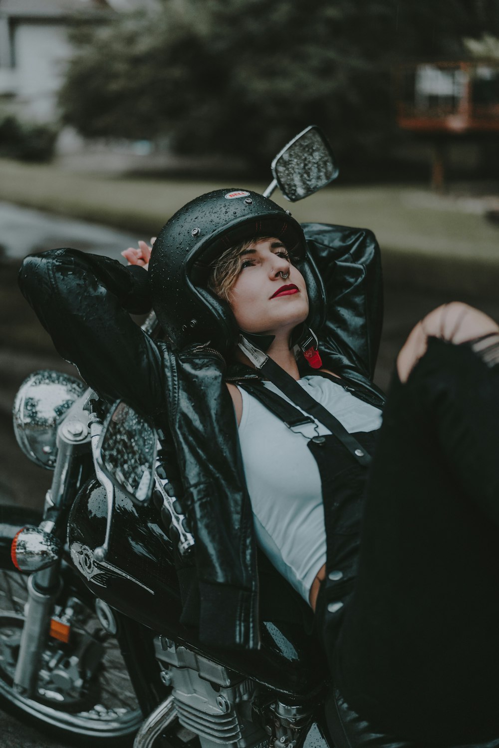 a woman sitting on a motorcycle wearing a helmet