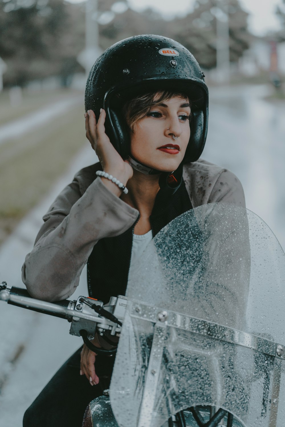 a woman sitting on a motorcycle with a helmet on