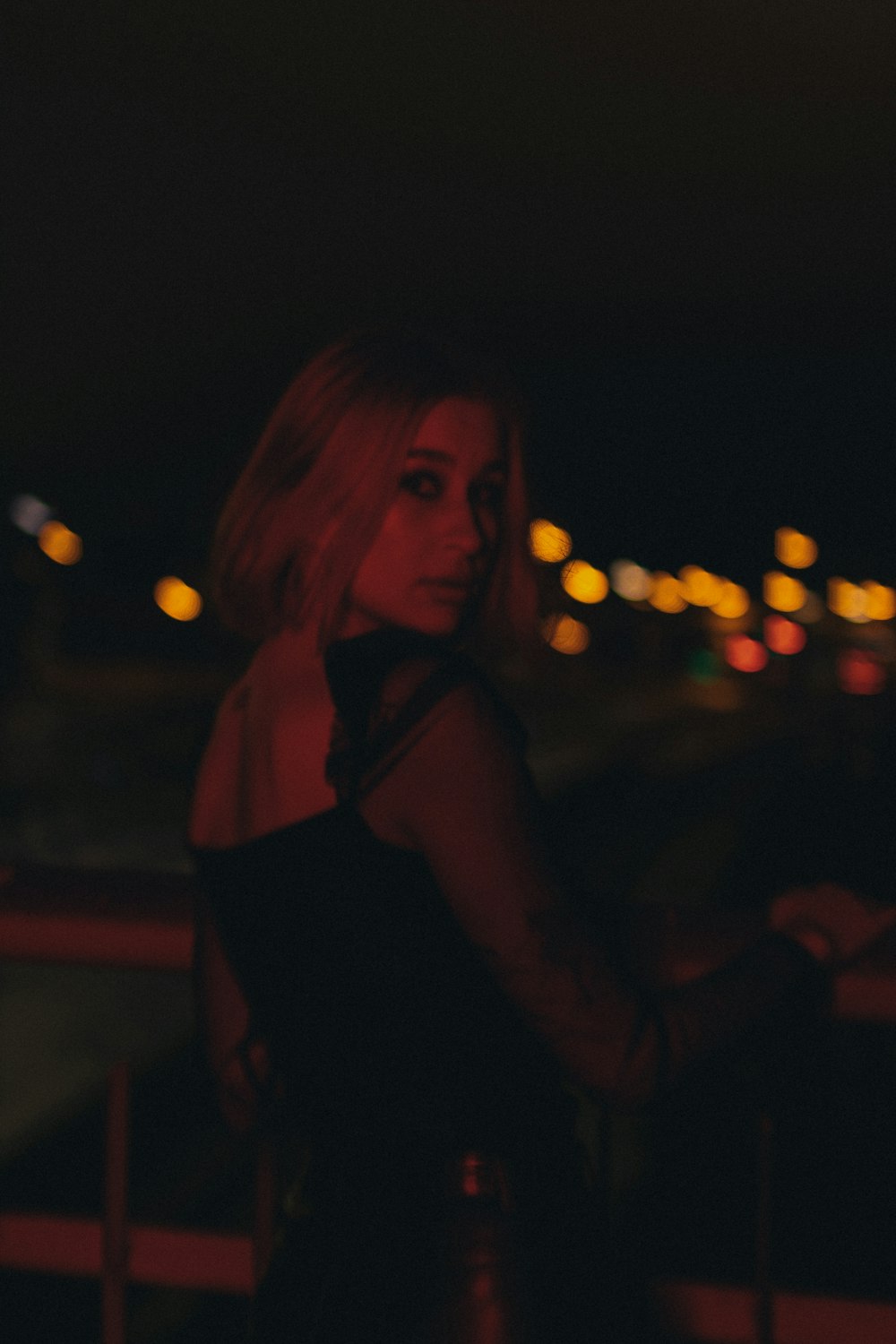 a woman in a black dress standing on a balcony