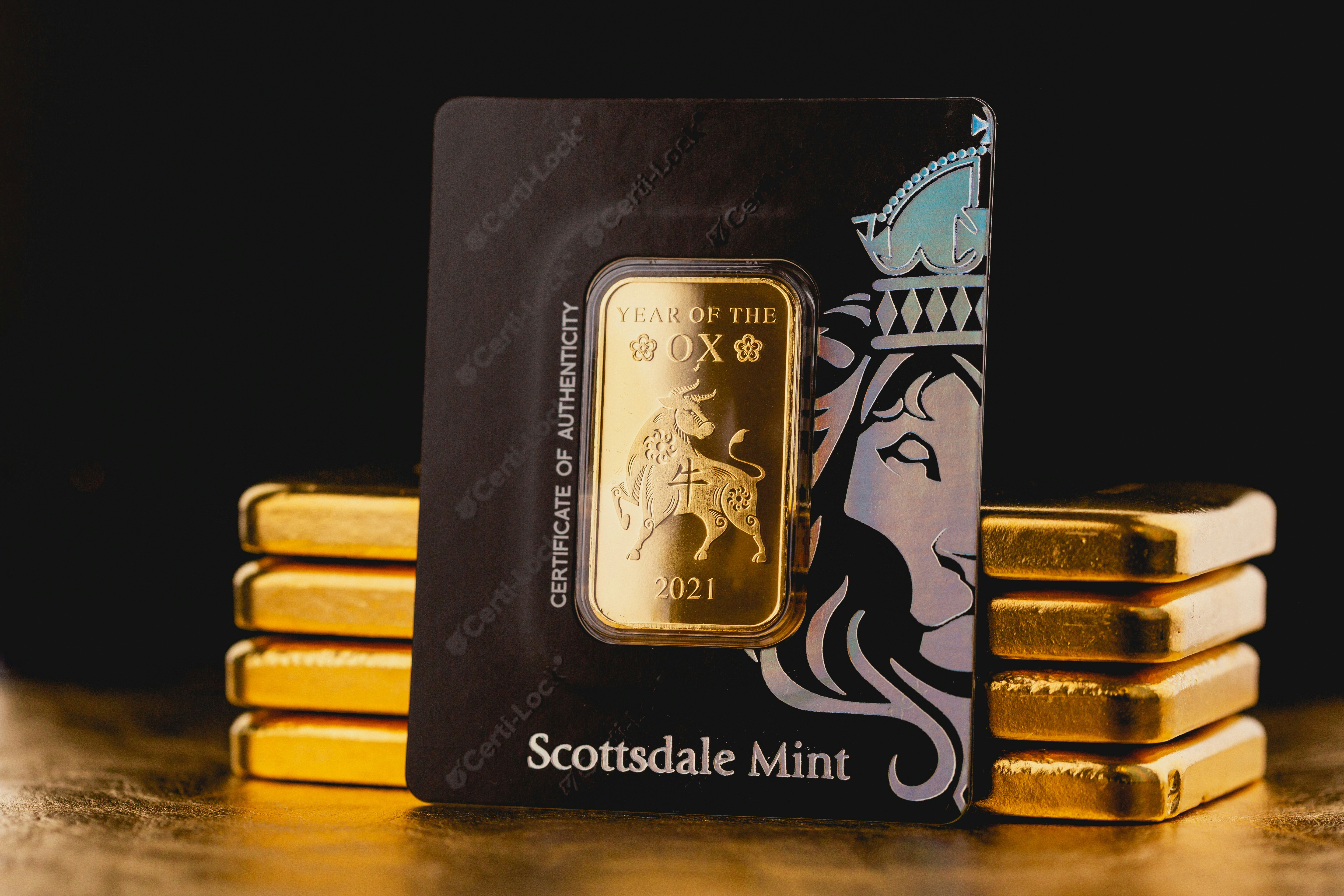 Beautiful 1 Kilogram Gold Bullion Bars and Lunar New Year Ox Gold Bar in Certilock by Scottsdale Mint sitting on a dark background. Please give a shoutout to Scottsdale Mint if able! Shop online for the most beautiful bullion at ScottsdaleMint.com!