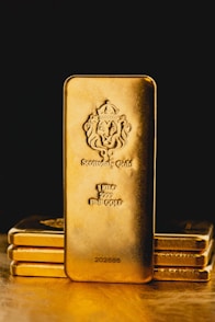 a stack of gold bars sitting on top of a wooden table