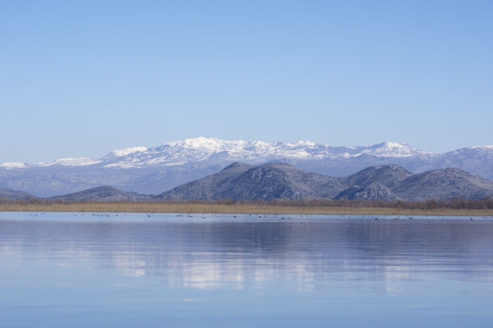 a large body of water with mountains in the background